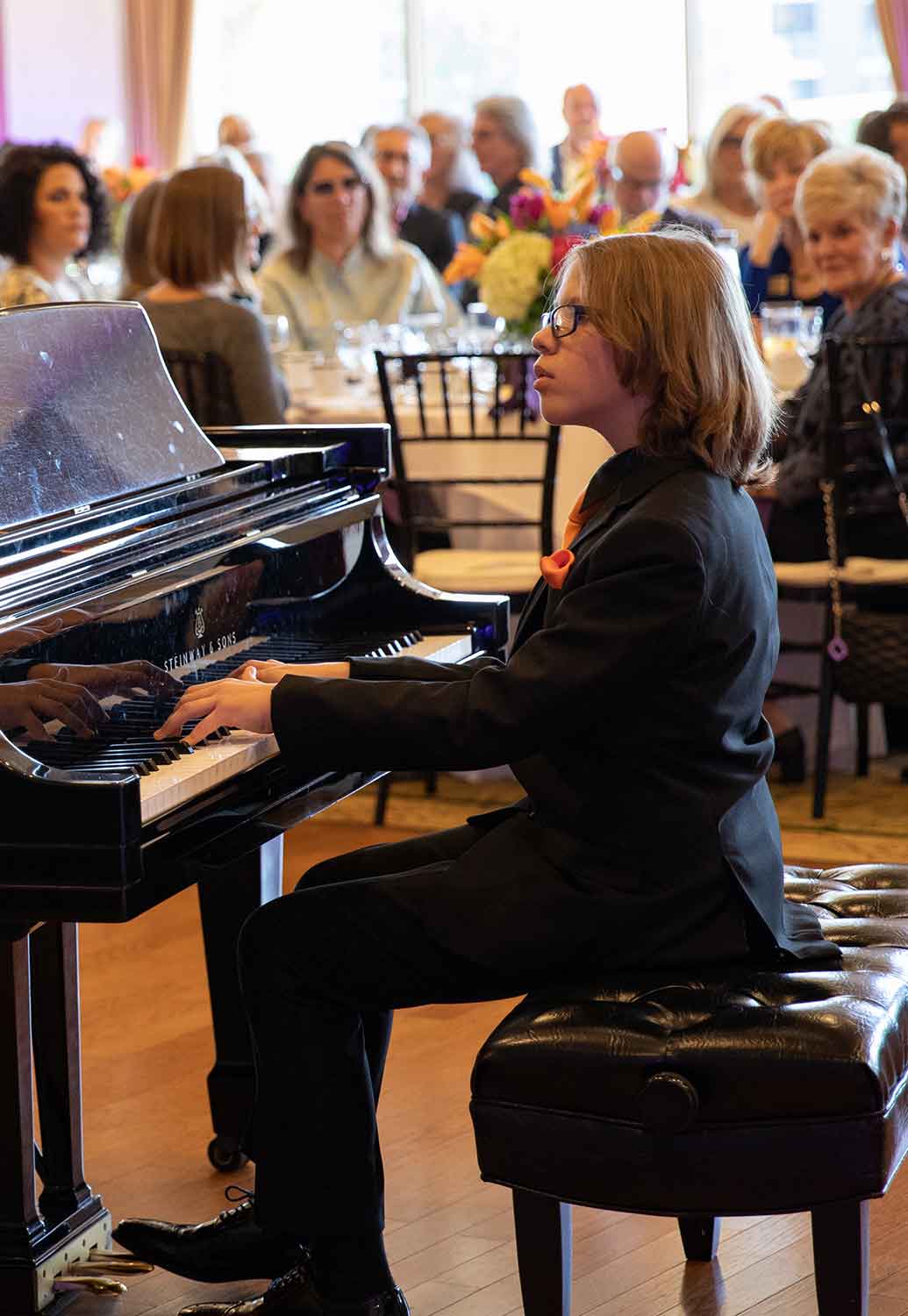 Young man playing Steinway piano at a festival in 2020
